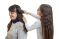 Little girl coms hair of her mother in studio Royalty Free Stock Photo