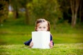 A little girl comtemplating her reading outside.