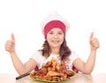 Little girl cook with roasted chicken drumstick and thumbs Royalty Free Stock Photo