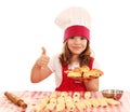 Little girl cook with rolls and thumb up