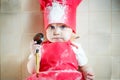 Little girl in a cook suit soiled in flour, closeup portrait