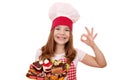 Little girl cook with sweet cakes andok hand sign Royalty Free Stock Photo