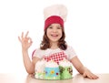 Little girl cook with sweet cakes and ok hand sign Royalty Free Stock Photo