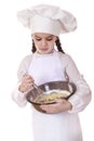 Little girl cook whips whisk eggs in a large plate Royalty Free Stock Photo