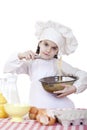 Little girl cook whips whisk eggs in a large plate Royalty Free Stock Photo