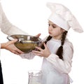 Little girl cook whips whisk eggs in a large plate Royalty Free Stock Photo