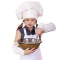 Little girl cook whips whisk eggs in a large plate