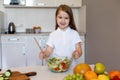 Little Girl Cooking Making Salad Smiling To Camera In Kitchen Royalty Free Stock Photo