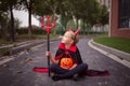 Little Girl in costume of devil with red horns in park. Happy Halloween concept Royalty Free Stock Photo