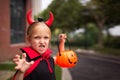 Little Girl in costume of devil with red horns in park. Happy Halloween concept Royalty Free Stock Photo