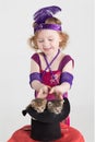 Little girl in costume magician pulls out kittens
