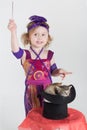 Little girl in costume magician waves her wand