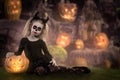 Little girl in a costume of witch posing with pumpkins over fairy background. halloween Royalty Free Stock Photo