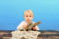 A little girl counts dollar bills and stacks them side by side on the table