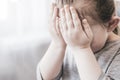 Little girl cries, covering her face with her hands