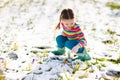 Little girl with crocus flowers under snow in spring Royalty Free Stock Photo