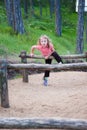 Little girl crossing wooden hurdles