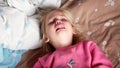 A little girl is crying on the bed. The child is very upset, he has hysterics