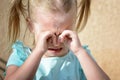 A little girl is crying and rubbing her eyes with her hands. Children`s hysteria. Royalty Free Stock Photo