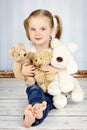 Little girl cuddling with plush toys