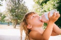 The little girl with curly golden hair pleasure drinks water fro Royalty Free Stock Photo