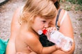 The little girl with curly golden hair pleasure drinks water fro Royalty Free Stock Photo