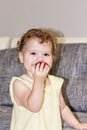 Little girl with curly hair eats an apple. Portrait of a child with an apple, eternal hazel eyes Royalty Free Stock Photo