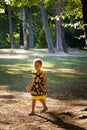 Little girl in cute summer dress walk in park