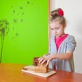 Little girl cuts the bread