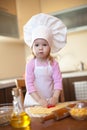 Little girl cuts dough for cookies on kitchen Royalty Free Stock Photo