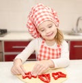 Little girl cuts dough with form for cookies Royalty Free Stock Photo