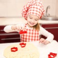 Little girl cuts dough with form for cookies Royalty Free Stock Photo