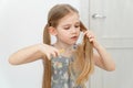 Little girl cutting hair to herself with scissors Royalty Free Stock Photo