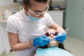 Little girl in 3D glasses sitting on destal chair at the office and have yearly checkup. Dentist with assistant