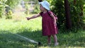 Little girl dabbles with Sprinkle hot day.