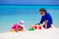 Little girl and dad playing with beach toys on Royalty Free Stock Photo