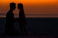 Little girl and dad silhouette in the sunset at the beach Royalty Free Stock Photo