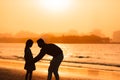 Little girl and dad silhouette in the sunset at the beach Royalty Free Stock Photo