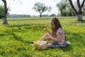 Little girl on dandelion lawn pick up dandelions in a basket Royalty Free Stock Photo