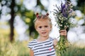 Little girl daughter collects a bouquet of wild flowers for mom. Mother`s Day