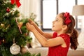 Little girl decorating christmas tree at home Royalty Free Stock Photo