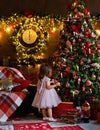A little girl is decorating a Christmas tree with toys. Cute baby is getting ready to go home to celebrate Christmas Royalty Free Stock Photo