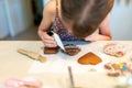 Little girl decorating gingerbread cookies with icing sugar. Royalty Free Stock Photo