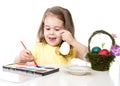 Little girl decorating traditional Easter egg