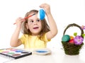 Little girl decorating traditional Easter egg