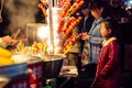 The little girl beside the delicatessen shop in Wuhan night market in late autumn