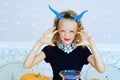 Little girl in demon costume playing with pumpkins