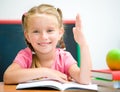 Little girl at the desk raised her hand Royalty Free Stock Photo