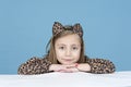 Little girl disguised as a leopard, isolated on blue