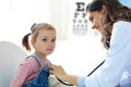 Little girl at the doctor for a checkup. Doctor woman auscultate the heartbeat of the child Royalty Free Stock Photo